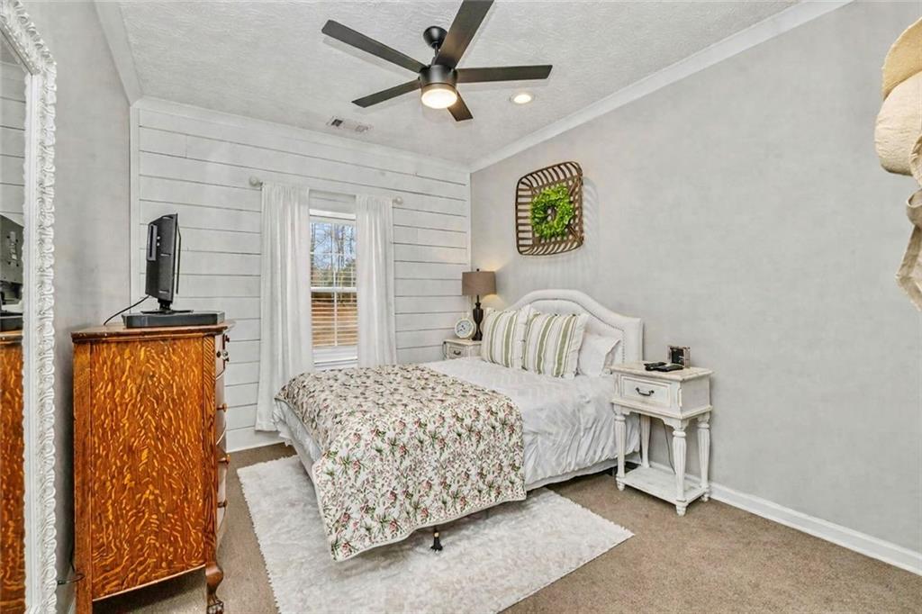 696 Highway 18 Barnesville, GA 30204 - Photo 26 of 57 a bedroom with a bed a dresser and a window