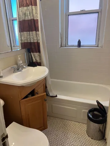 a bathroom with a sink a toilet and a shower curtain