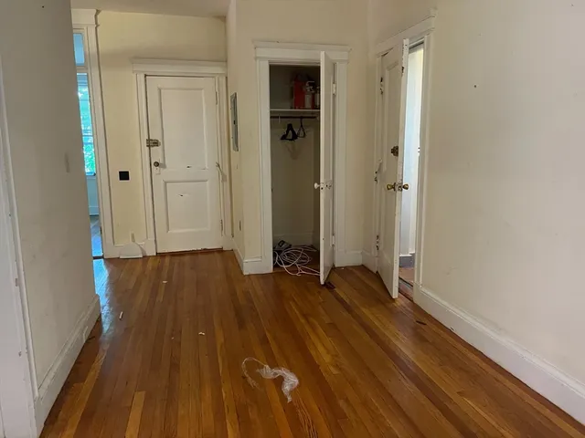 a view of a hallway with wooden floor and staircase