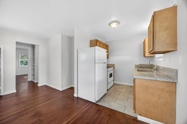 a kitchen with granite countertop a refrigerator and a sink