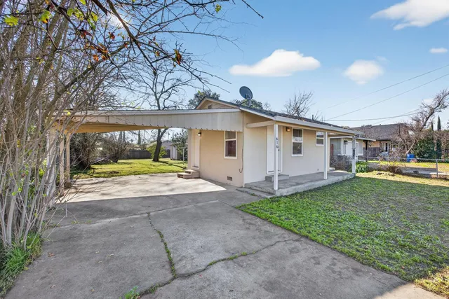 a view of a house with backyard and sitting area