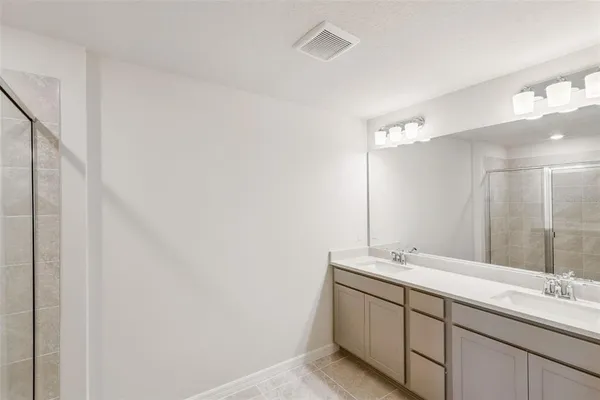 a bathroom with a double vanity sink and a mirror