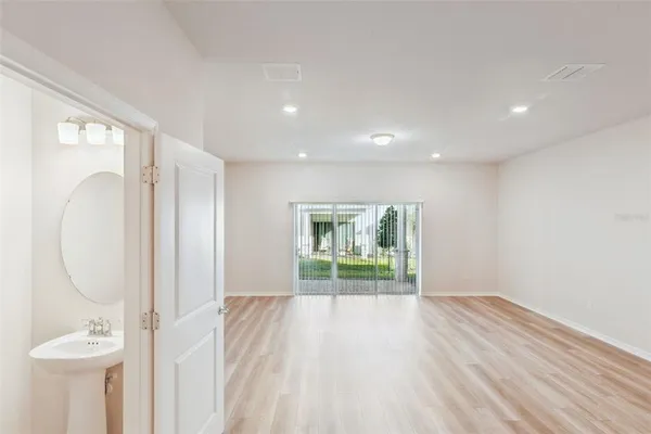 a view of a livingroom with wooden floor and a ceiling fan