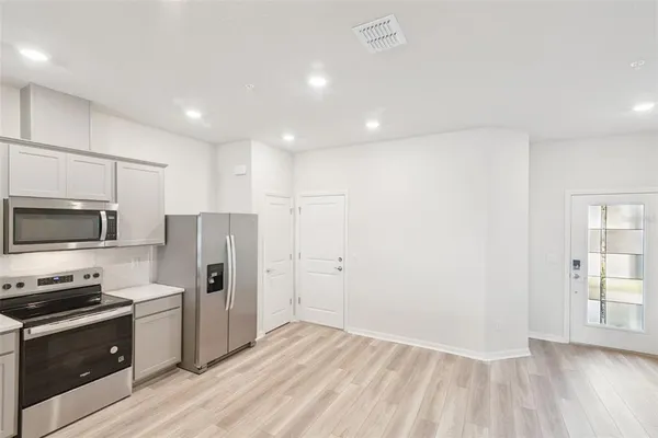 a kitchen with stainless steel appliances a refrigerator and a stove top oven