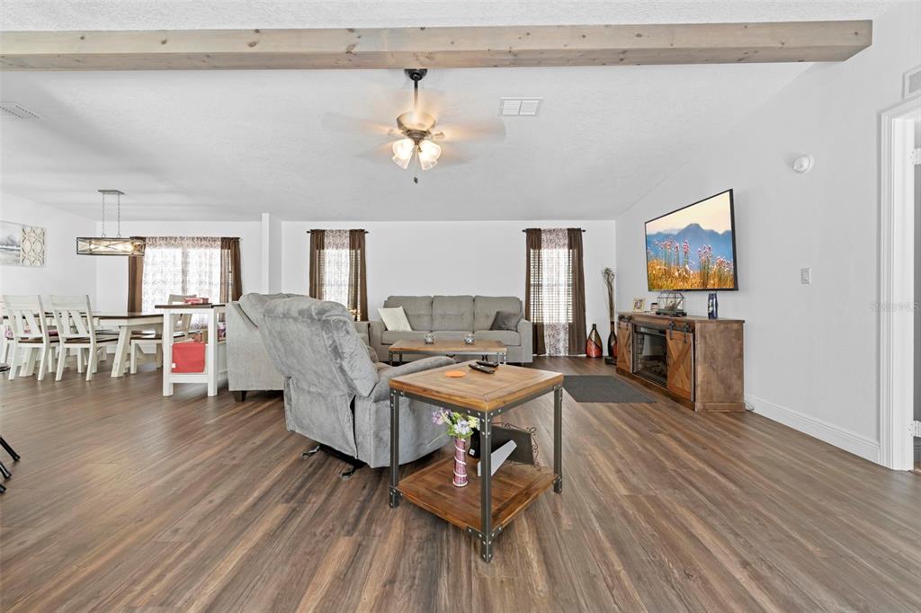 17095 Frankfort Road Brooksville, FL 34601 - Photo 17 of 42 a living room with couches chairs and kitchen view with wooden floor
