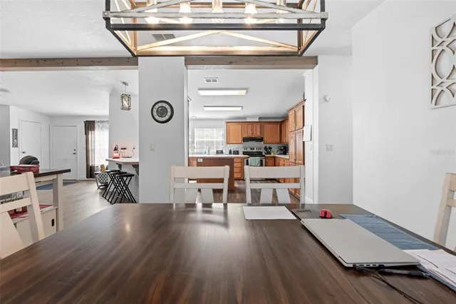 a kitchen with stainless steel appliances granite countertop a refrigerator a sink dishwasher a stove with wooden floor and cabinets