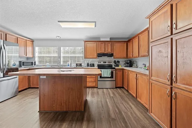 a kitchen with a sink appliances cabinets and furniture