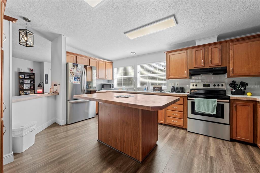 17095 Frankfort Road Brooksville, FL 34601 - Photo 29 of 42 a kitchen with stainless steel appliances granite countertop a stove a sink dishwasher a refrigerator and a oven with wooden floor
