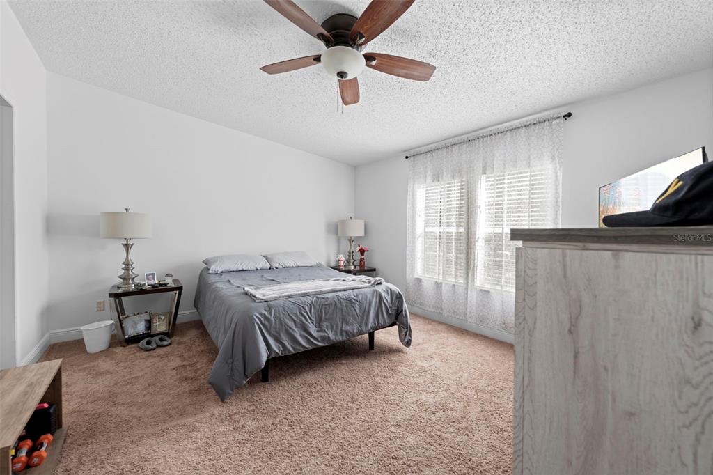 17095 Frankfort Road Brooksville, FL 34601 - Photo 34 of 42 a spacious bedroom with a bed and a chandelier