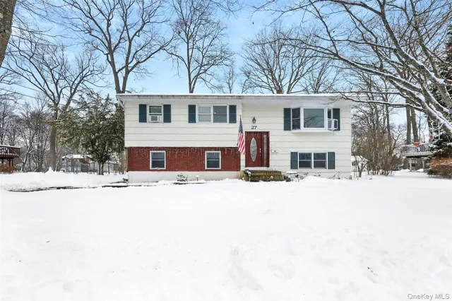 a front view of house with a yard covered in snow