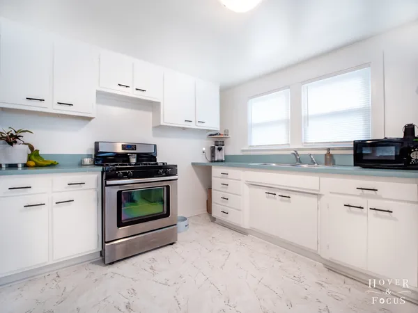 a kitchen with cabinets appliances and a window
