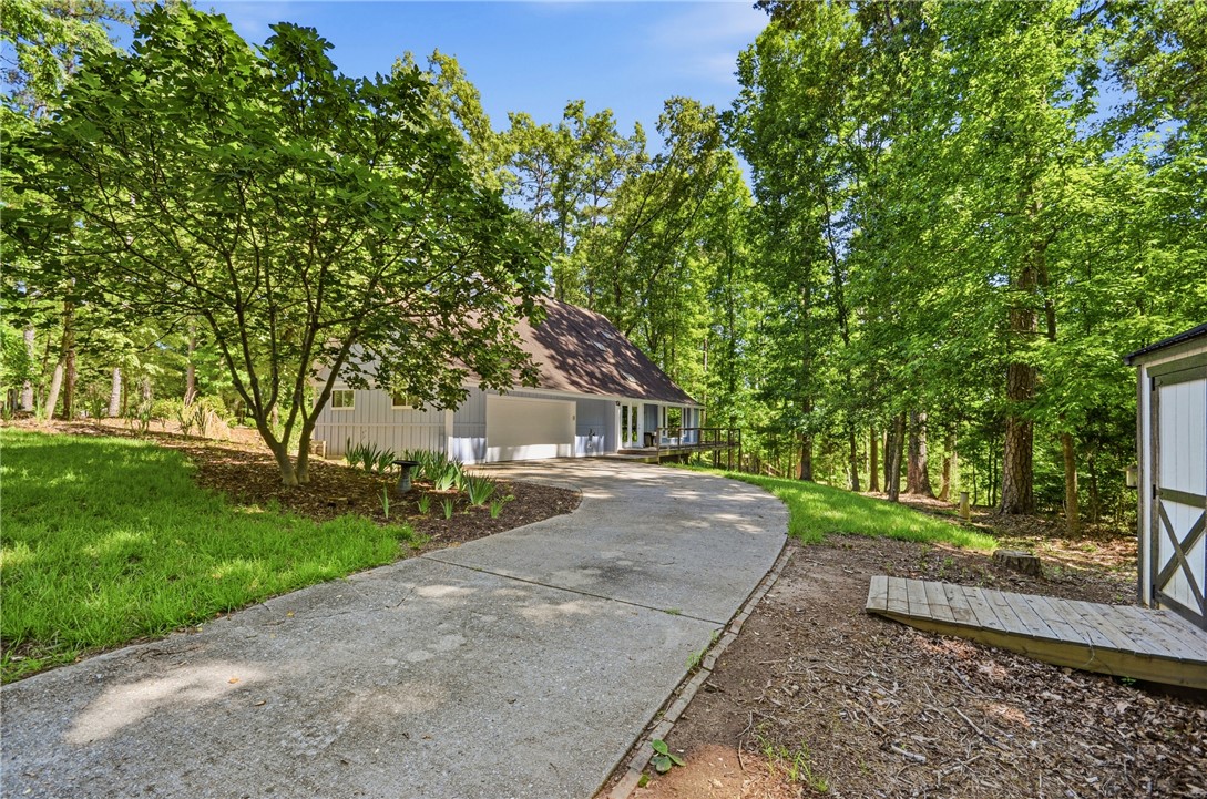 1298 Carradine Road Seneca, SC 29678 - Photo 37 of 43 A winding driveway leads to a secluded home nestled among a lush, mature tree canopy.