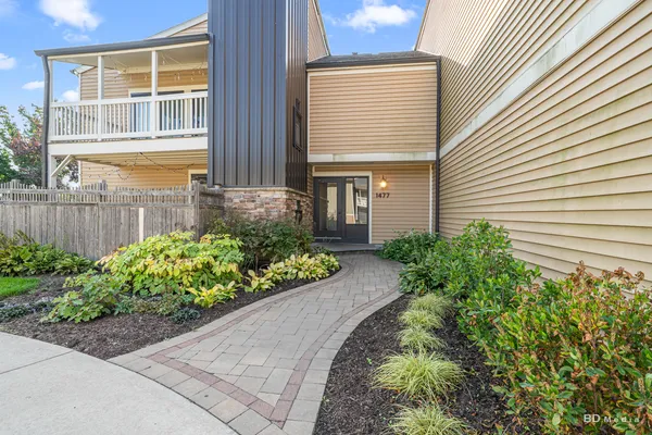 a front view of a house with a yard and potted plants