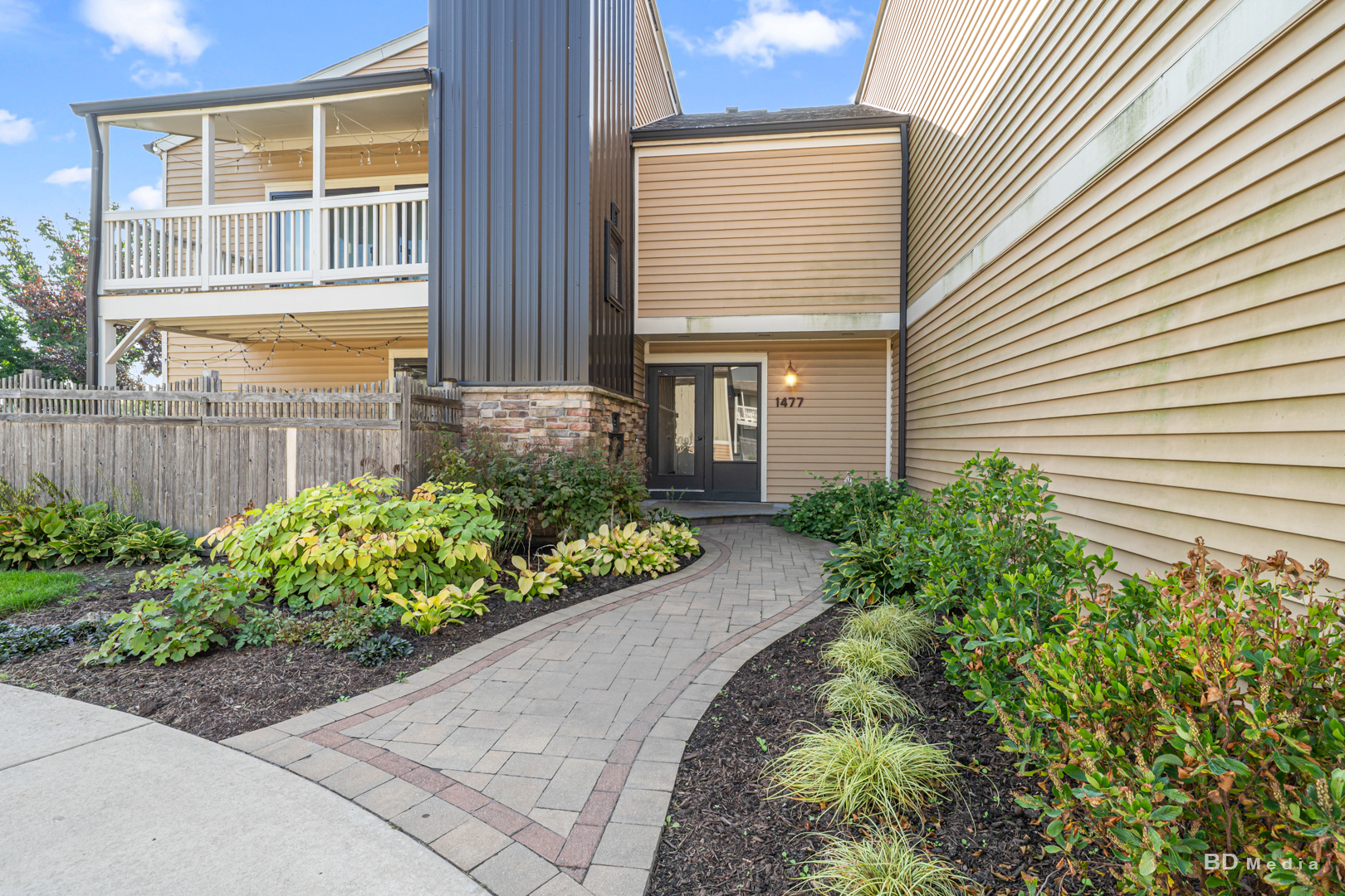 a front view of a house with a yard and potted plants