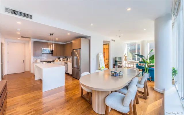 a kitchen with a dining table chairs and refrigerator