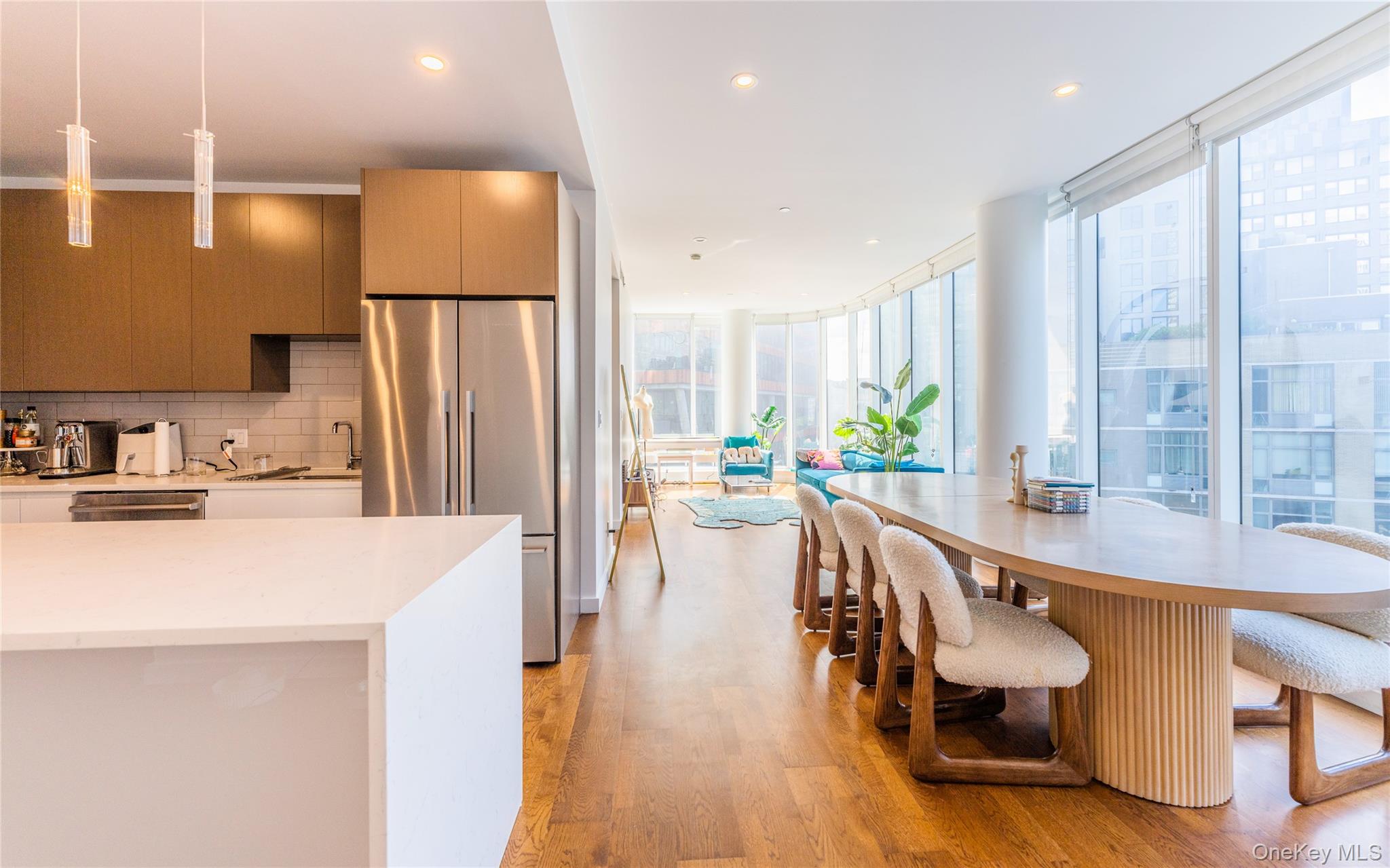 27-17 42nd Road, Unit 7E Queens, NY 11101 - Photo 13 of 42 a dining hall with stainless steel appliances granite countertop a refrigerator a sink a dining table and chairs with wooden floor