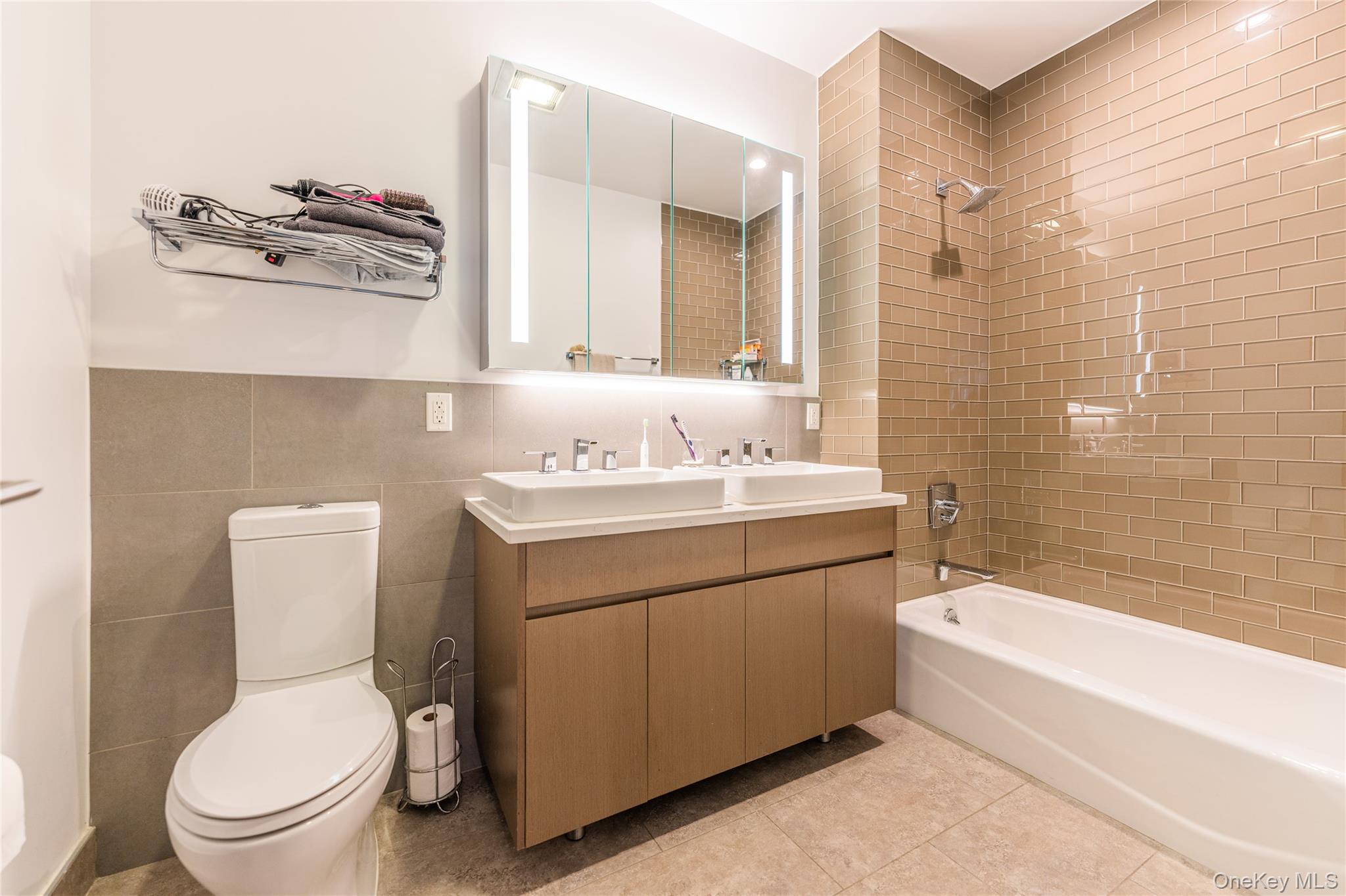 27-17 42nd Road, Unit 7E Queens, NY 11101 - Photo 16 of 42 a bathroom with a sink a toilet and shower