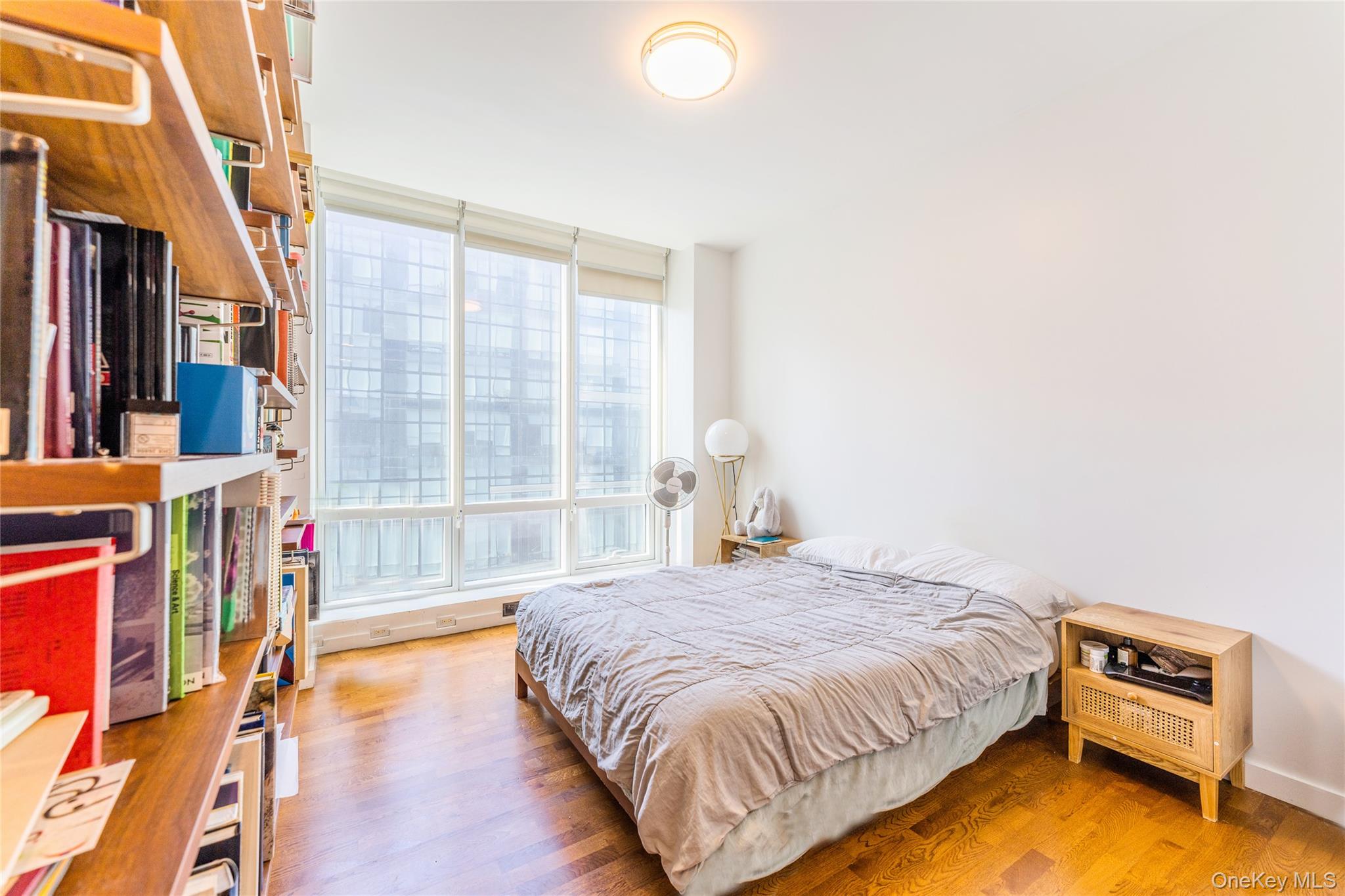 27-17 42nd Road, Unit 7E Queens, NY 11101 - Photo 17 of 42 a bedroom with a bed and a large window