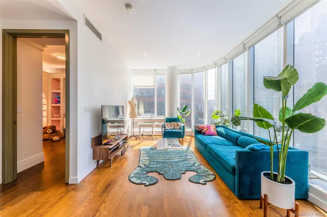 a living room with furniture fireplace and large windows