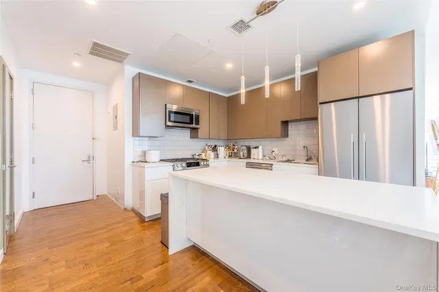 a kitchen with kitchen island a sink stainless steel appliances and cabinets