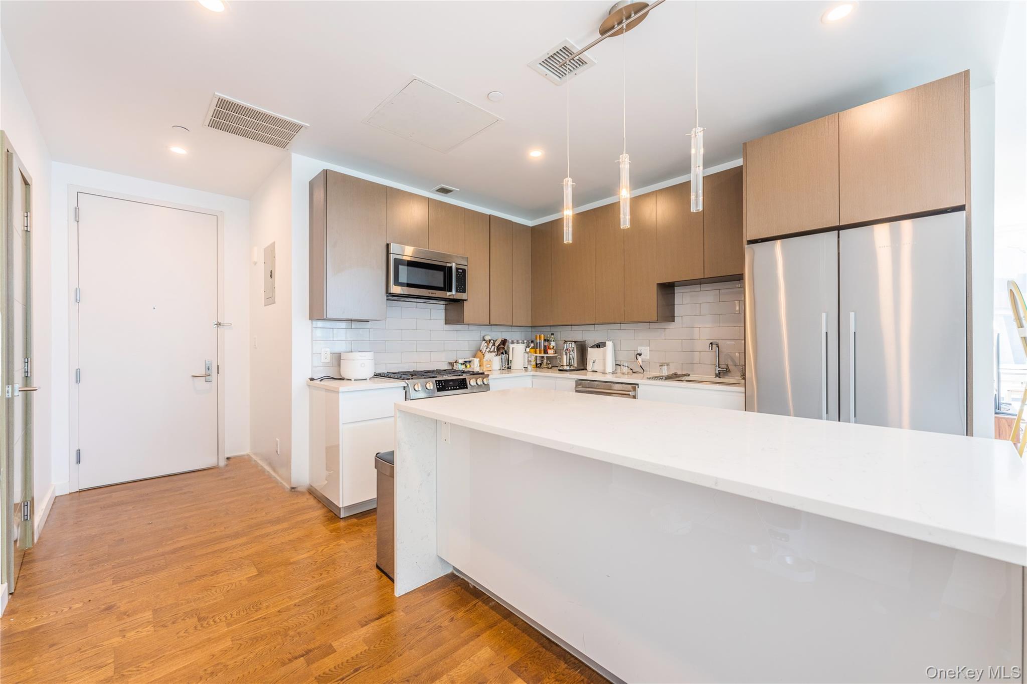 27-17 42nd Road, Unit 7E Queens, NY 11101 - Photo 10 of 42 a kitchen with kitchen island a sink stainless steel appliances and cabinets