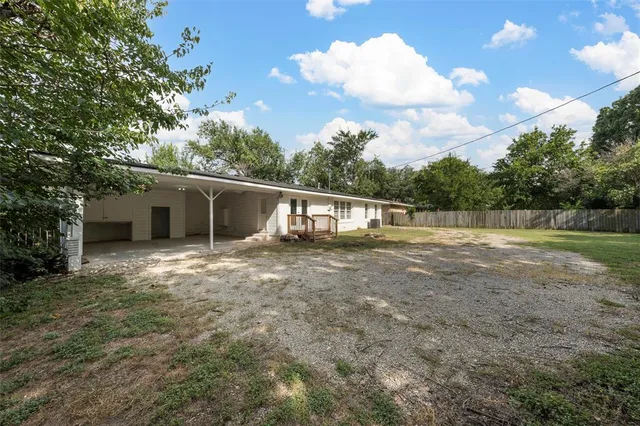a view of a house with backyard and a tree