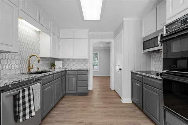 a kitchen with stainless steel appliances granite countertop a stove a sink and a refrigerator