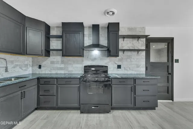a kitchen with stainless steel appliances granite countertop a stove and cabinets