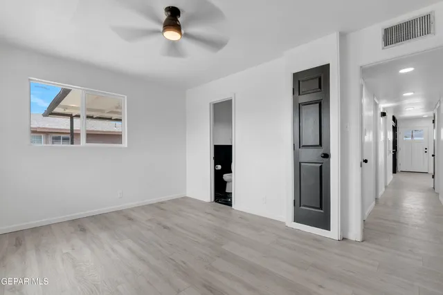 a view of a big room with wooden floor and windows