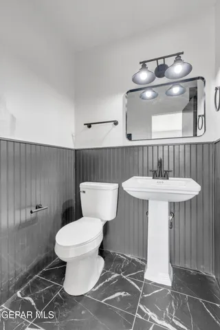 a bathroom with a sink a toilet and a mirror