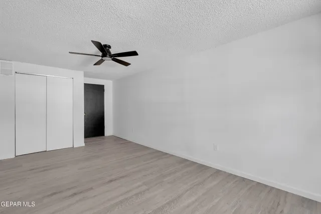 a view of a big room with wooden floor and a ceiling fan