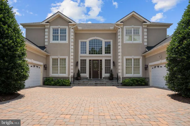 a front view of a house with a yard and trees