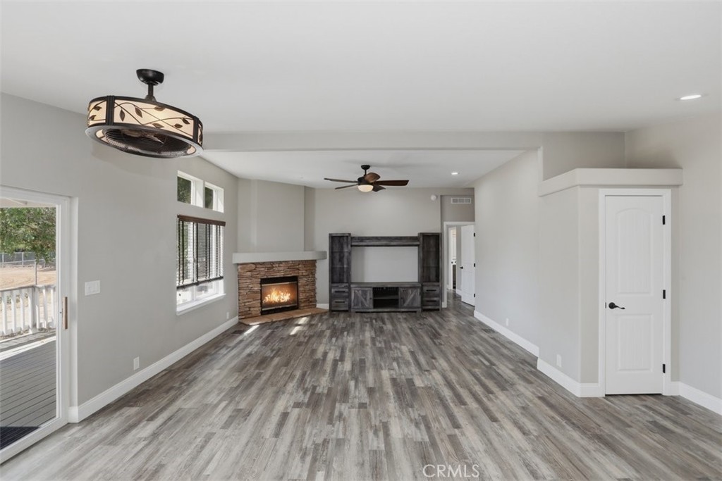 33634 Howard Way Menifee, CA 92584 - Photo 19 of 53 an empty room with windows fireplace and wooden floor