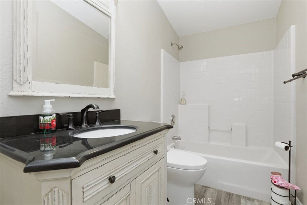 33634 Howard Way Menifee, CA 92584 - Photo 27 of 53 a bathroom with a granite countertop sink a toilet and bathtub