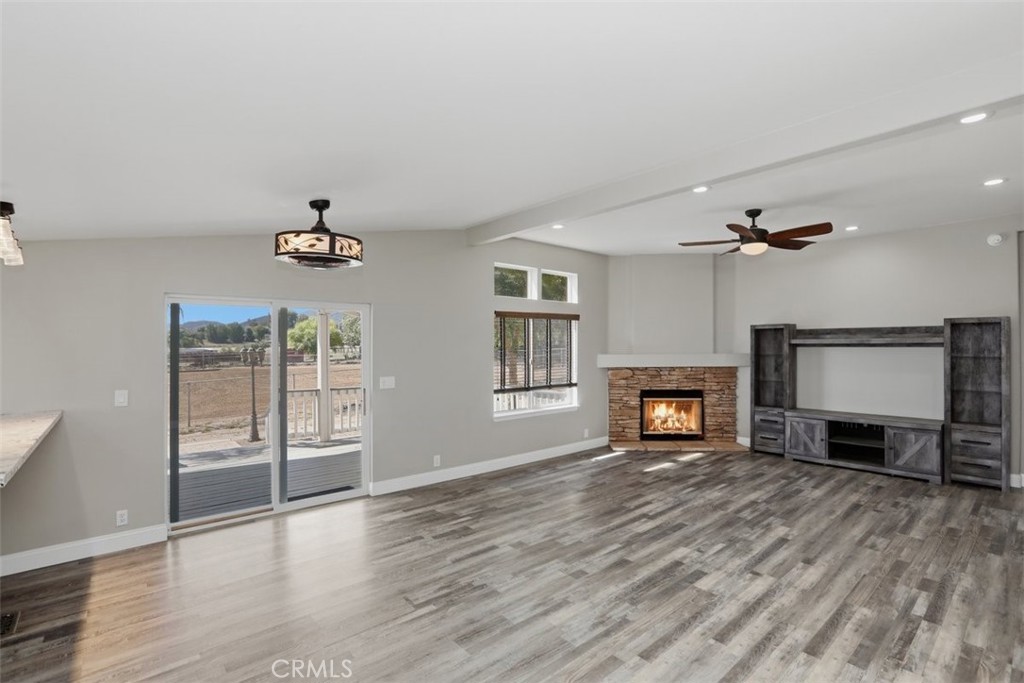 33634 Howard Way Menifee, CA 92584 - Photo 10 of 53 an empty room with windows fireplace and wooden floor