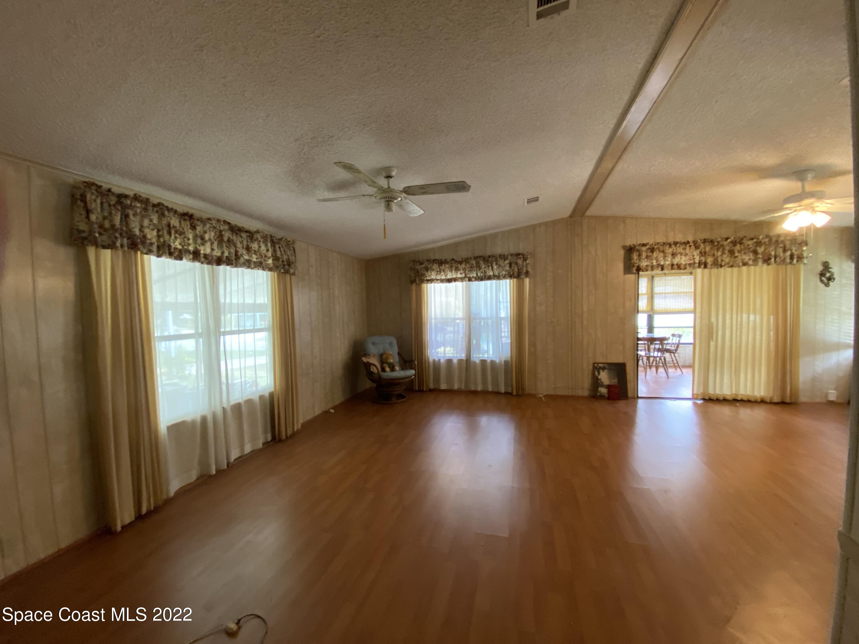 1352 Barefoot Circle Barefoot Bay, FL 32976 - Photo 15 of 40 a view of a livingroom with wooden floor and a large window
