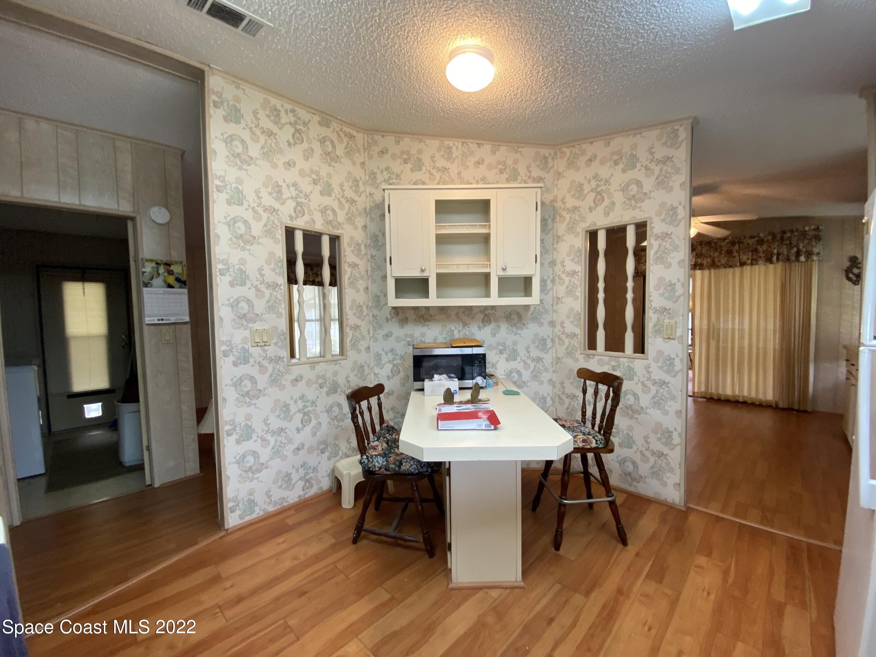 1352 Barefoot Circle Barefoot Bay, FL 32976 - Photo 20 of 40 a view of a dining room with furniture and wooden floor