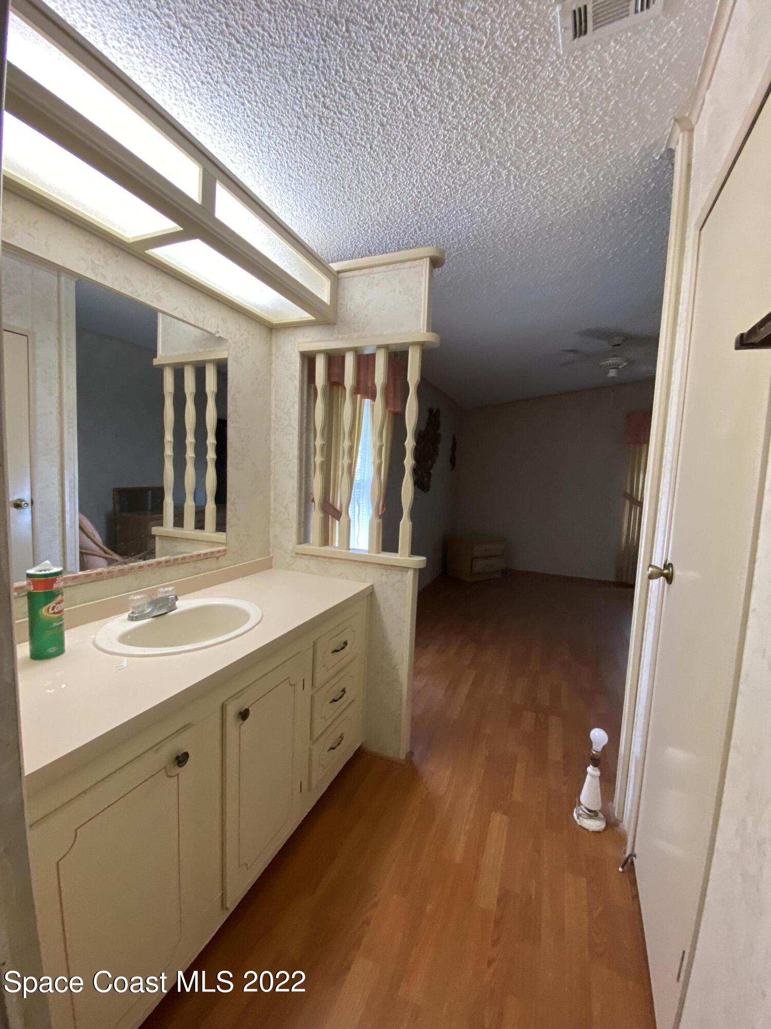 1352 Barefoot Circle Barefoot Bay, FL 32976 - Photo 38 of 40 a bathroom with a sink a mirror and a toilet