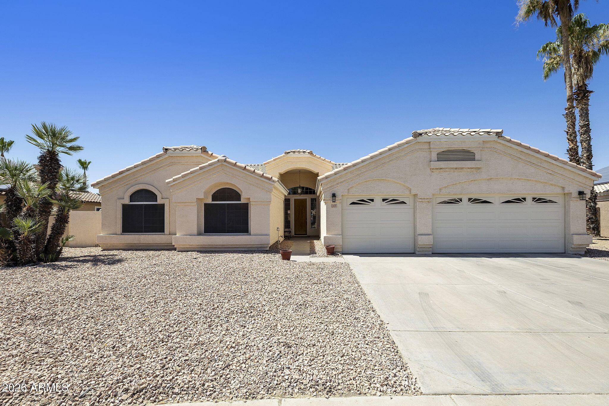 12435 West Monte Vista Road Avondale, AZ 85392 - Photo 5 of 69 a large white house with a large tree and a large parking space
