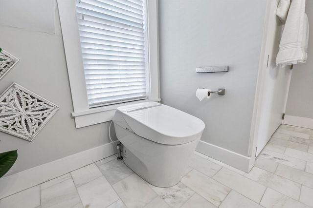 a bathroom with a toilet and a window