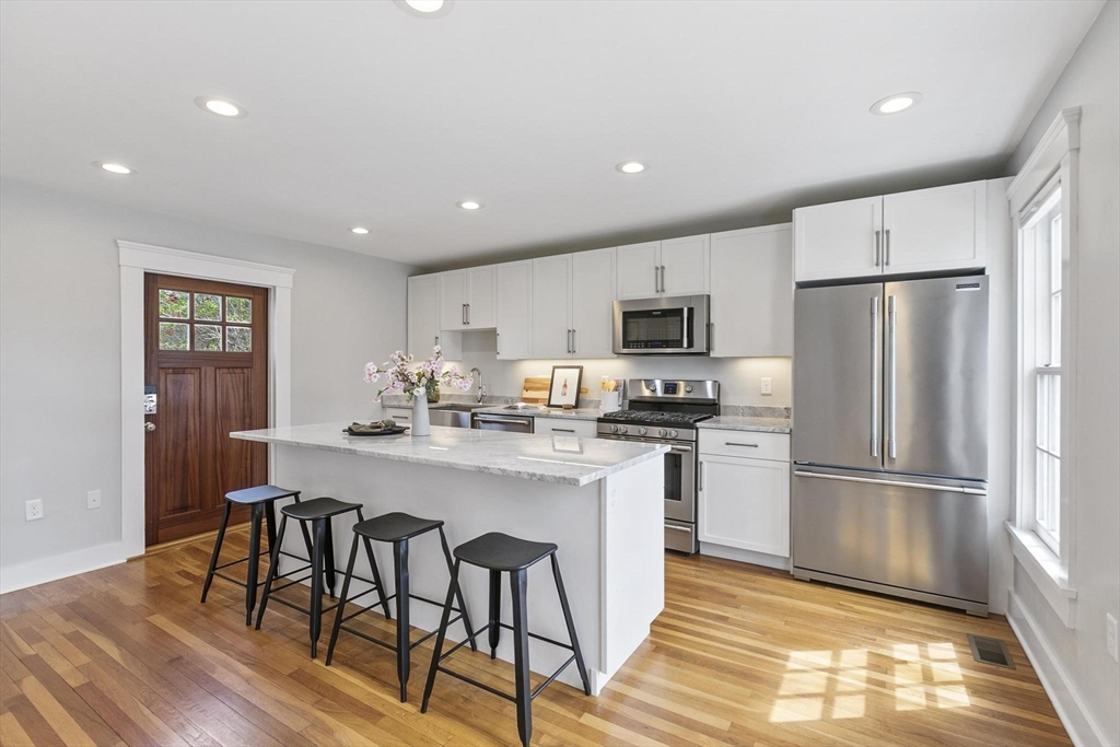 591 Somerville Avenue, Unit 7 Somerville, MA 02143 - Photo 2 of 20 a kitchen with refrigerator cabinets and wooden floor