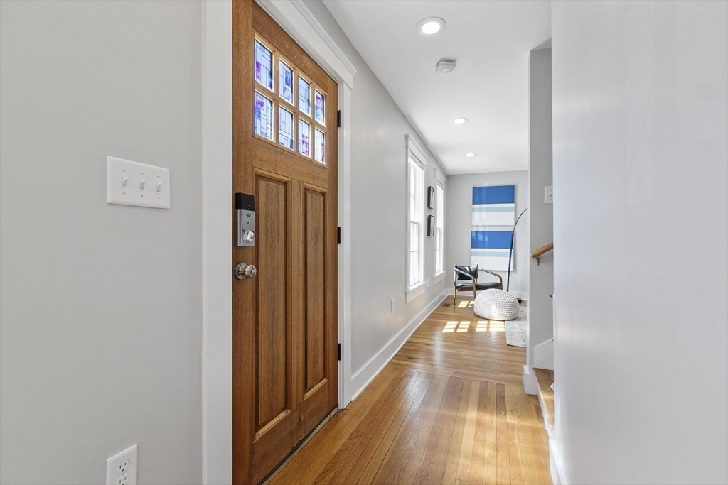 591 Somerville Avenue, Unit 7 Somerville, MA 02143 - Photo 3 of 20 a view of a hallway with a dining area with chandelier