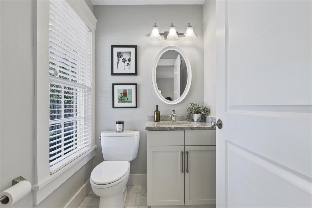 591 Somerville Avenue, Unit 7 Somerville, MA 02143 - Photo 7 of 20 a bathroom with a toilet sink vanity and mirror