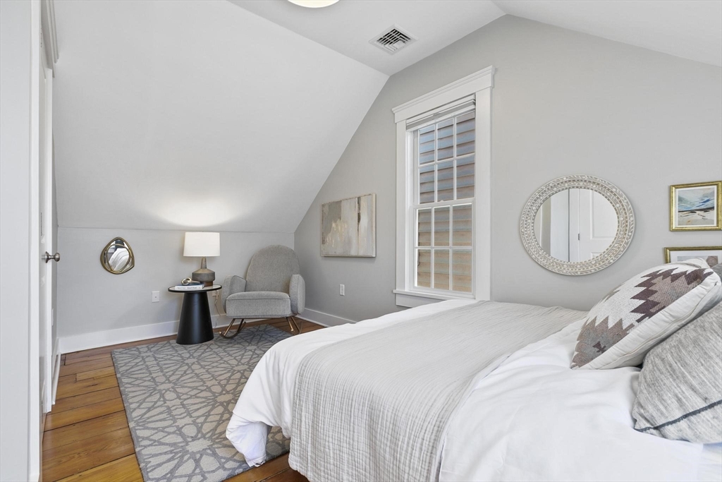 591 Somerville Avenue, Unit 7 Somerville, MA 02143 - Photo 10 of 20 a bedroom with a bed and wooden floor