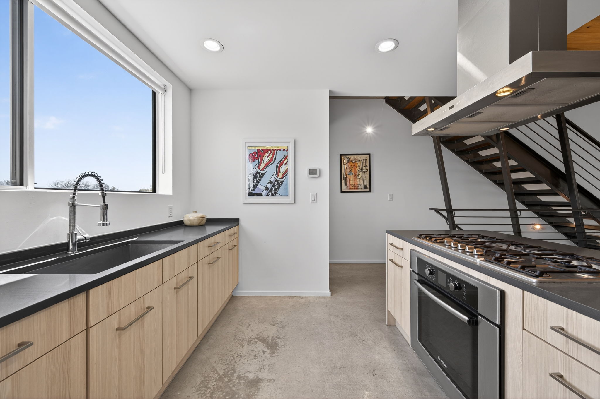 2301 South 5th Street, Unit 25 Austin, TX 78704 - Photo 10 of 35 Kitchen featuring concrete floors, extractor fan, stainless steel appliances, light wood finish cabinets, and recessed lighting