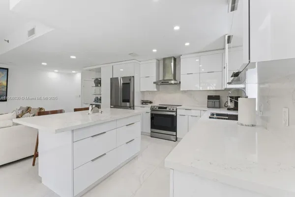 a kitchen with white cabinets and stainless steel appliances