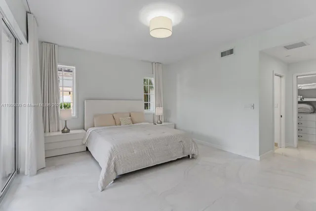 a bedroom with a bed and a large window