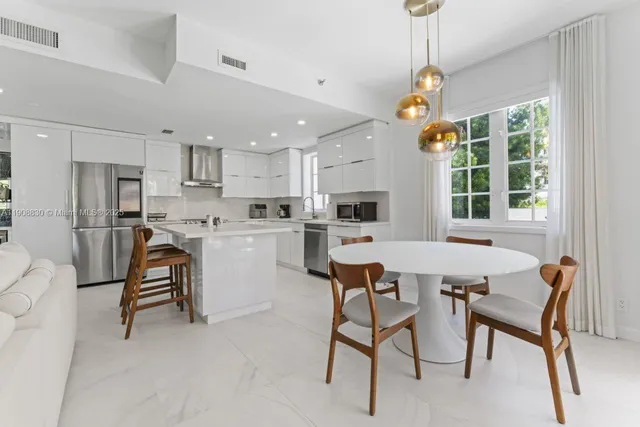 a view of a dining room and livingroom with furniture wooden floor a chandelier