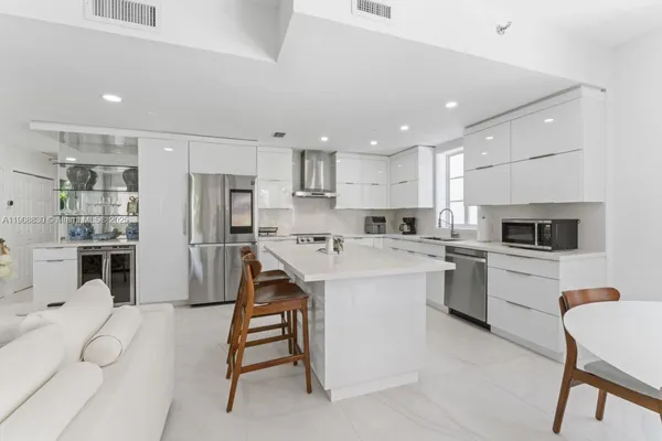a kitchen with white cabinets and stainless steel appliances