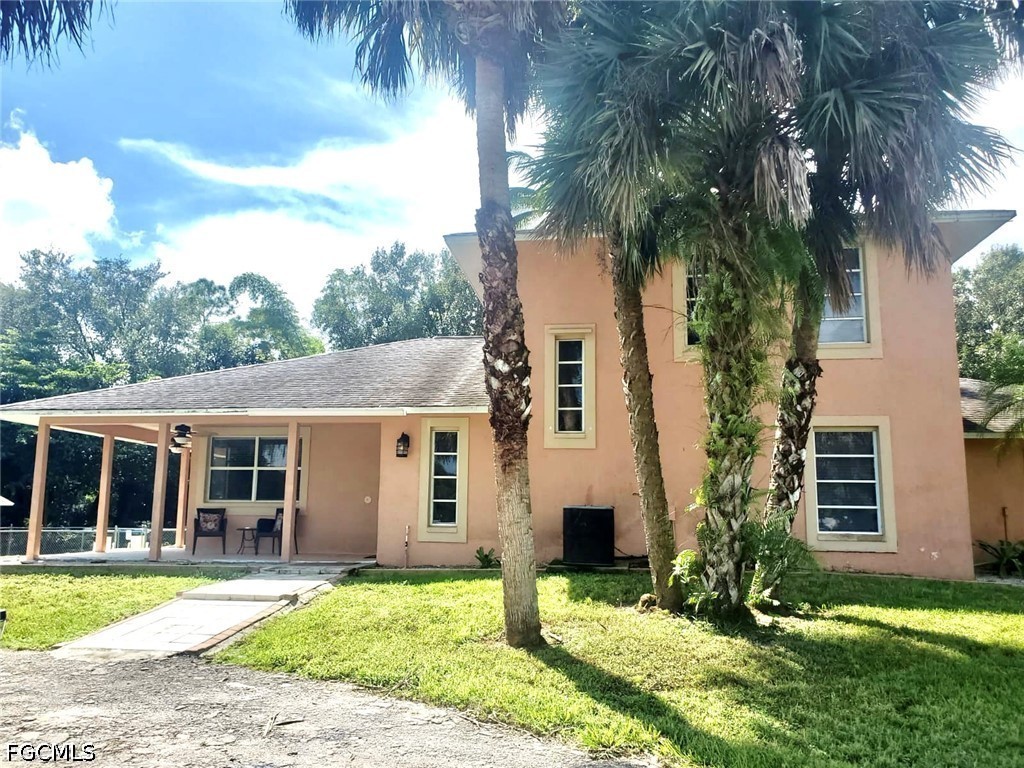 740 19th Street Southwest Naples, FL 34117 - Photo 2 of 35 a front view of a house with a yard and porch